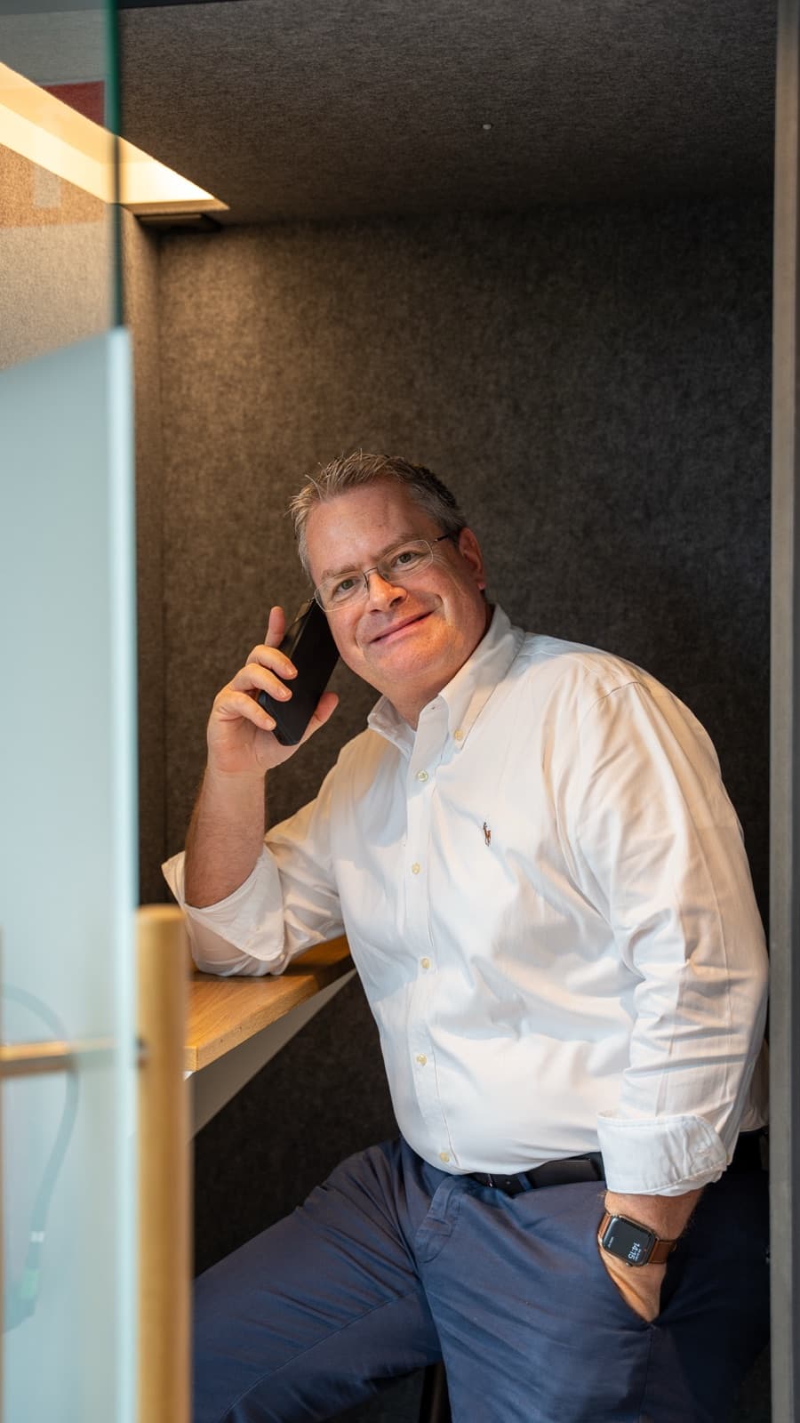 Xavier Gabriëls belt staand in een rustige vergaderruimte.